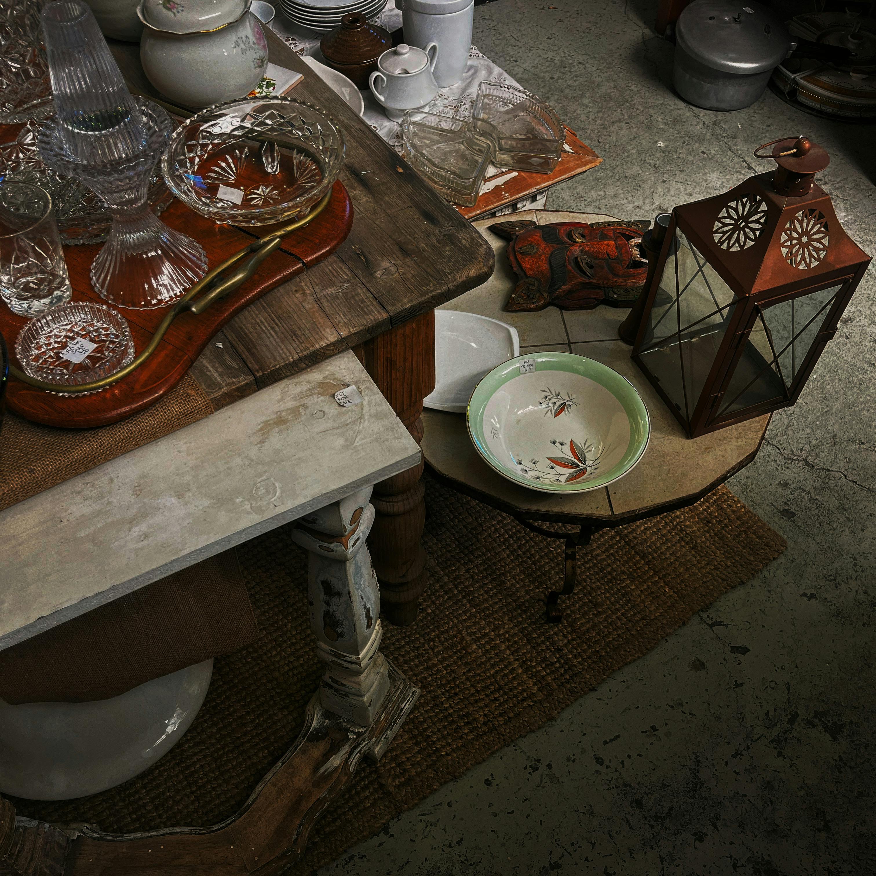 Vintage tableware and lantern arrangement creating an artistic rustic vibe.