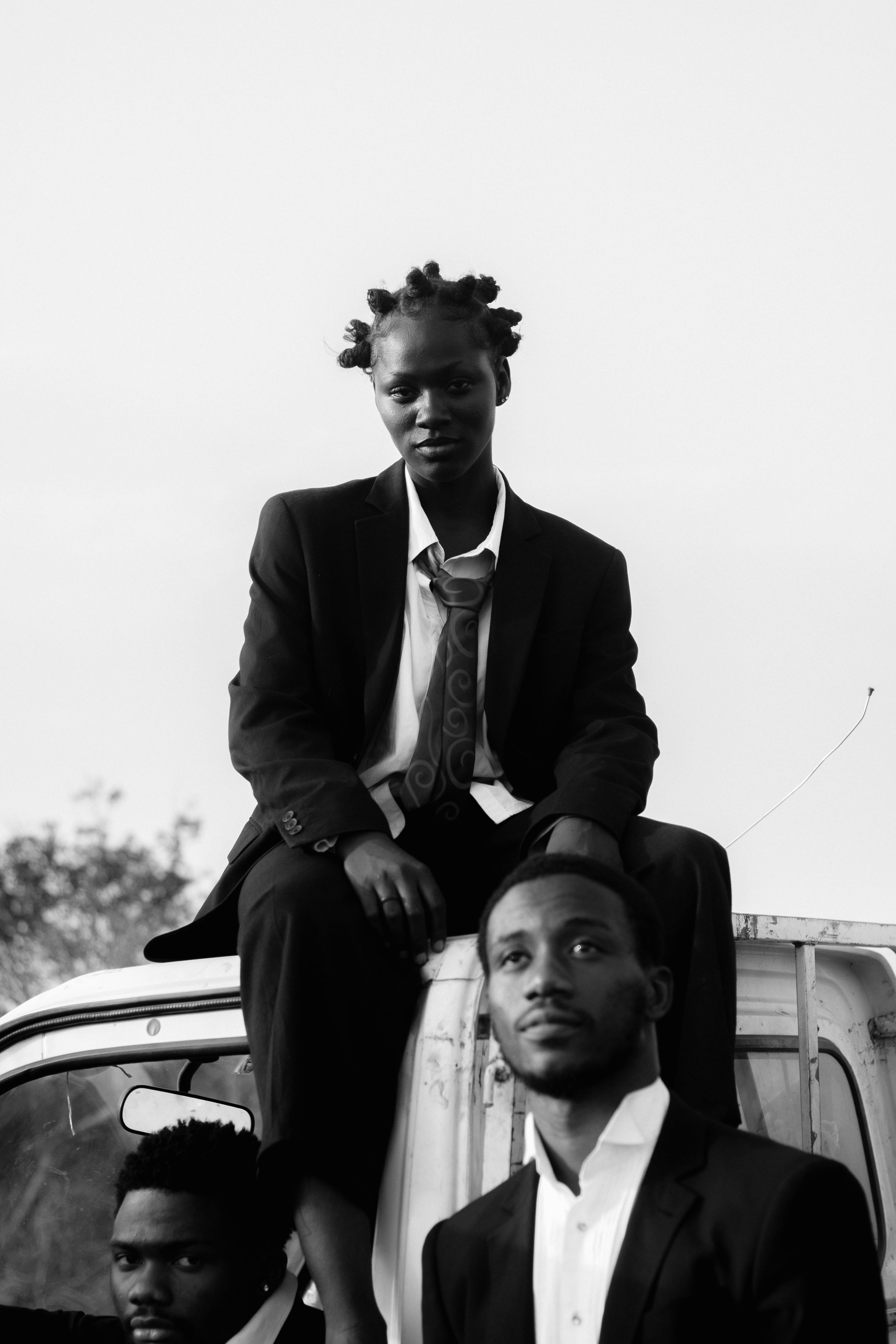 Black and white photo of men in suits, presenting modern fashion elegance.