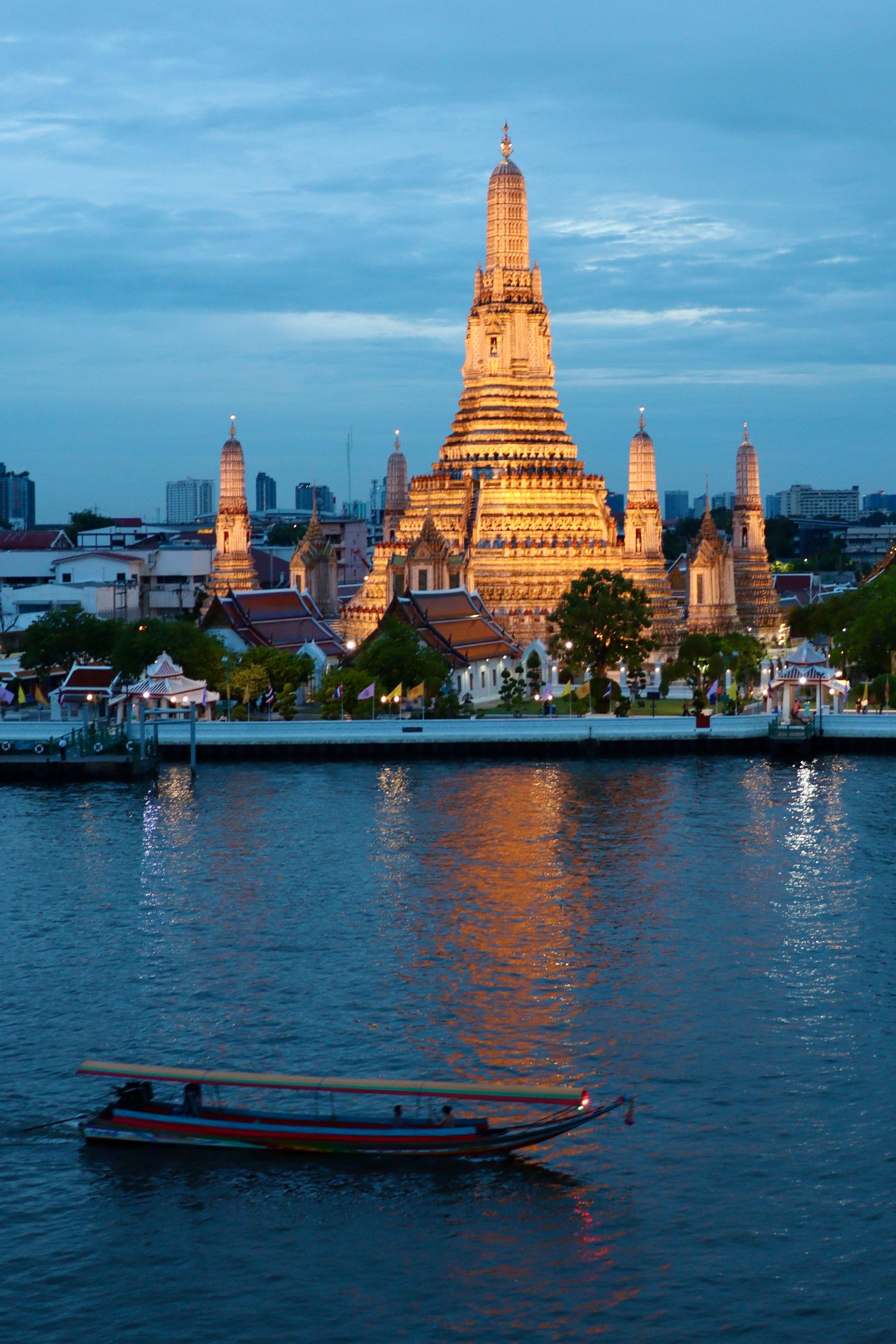 Wat Arun beside the Chao Phraya River in Bangkok at evening