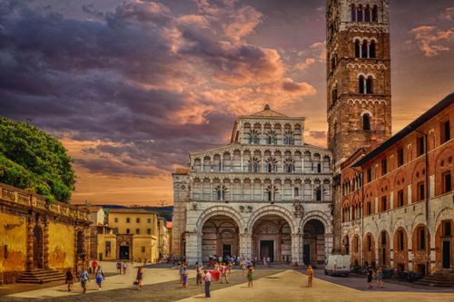 Free Capture of Lucca Cathedral at sunset, showcasing gothic architecture and bustling tourists. Stock Photo
