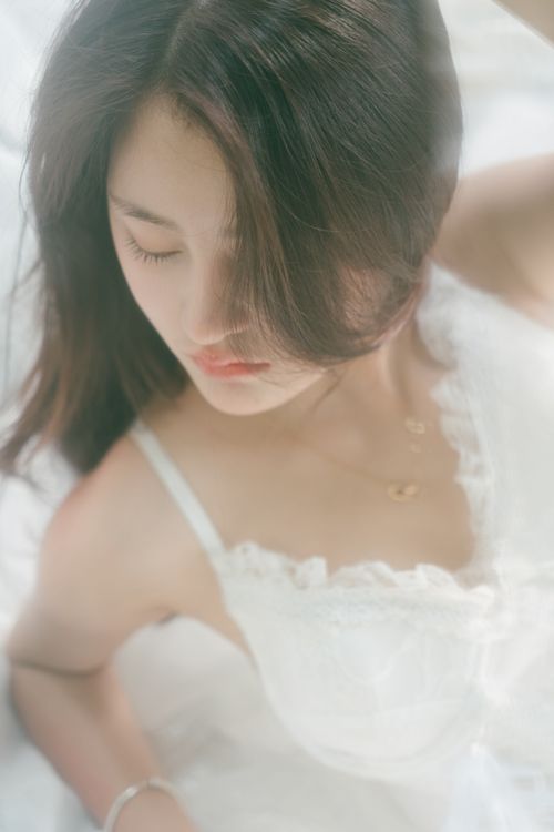 Free An artistic and gentle portrait of a woman lying down, captured in natural soft light. Stock Photo
