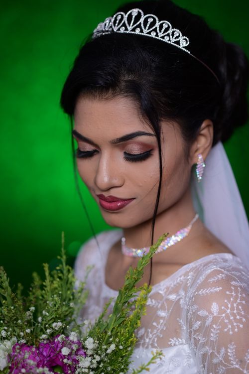 Free Close-up portrait of a bride with a bouquet, captured in an elegant studio setting. Stock Photo