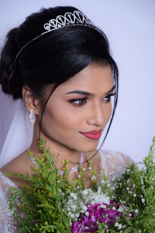 Free Portrait of a beautiful bride with a floral bouquet and tiara in a studio setting. Stock Photo