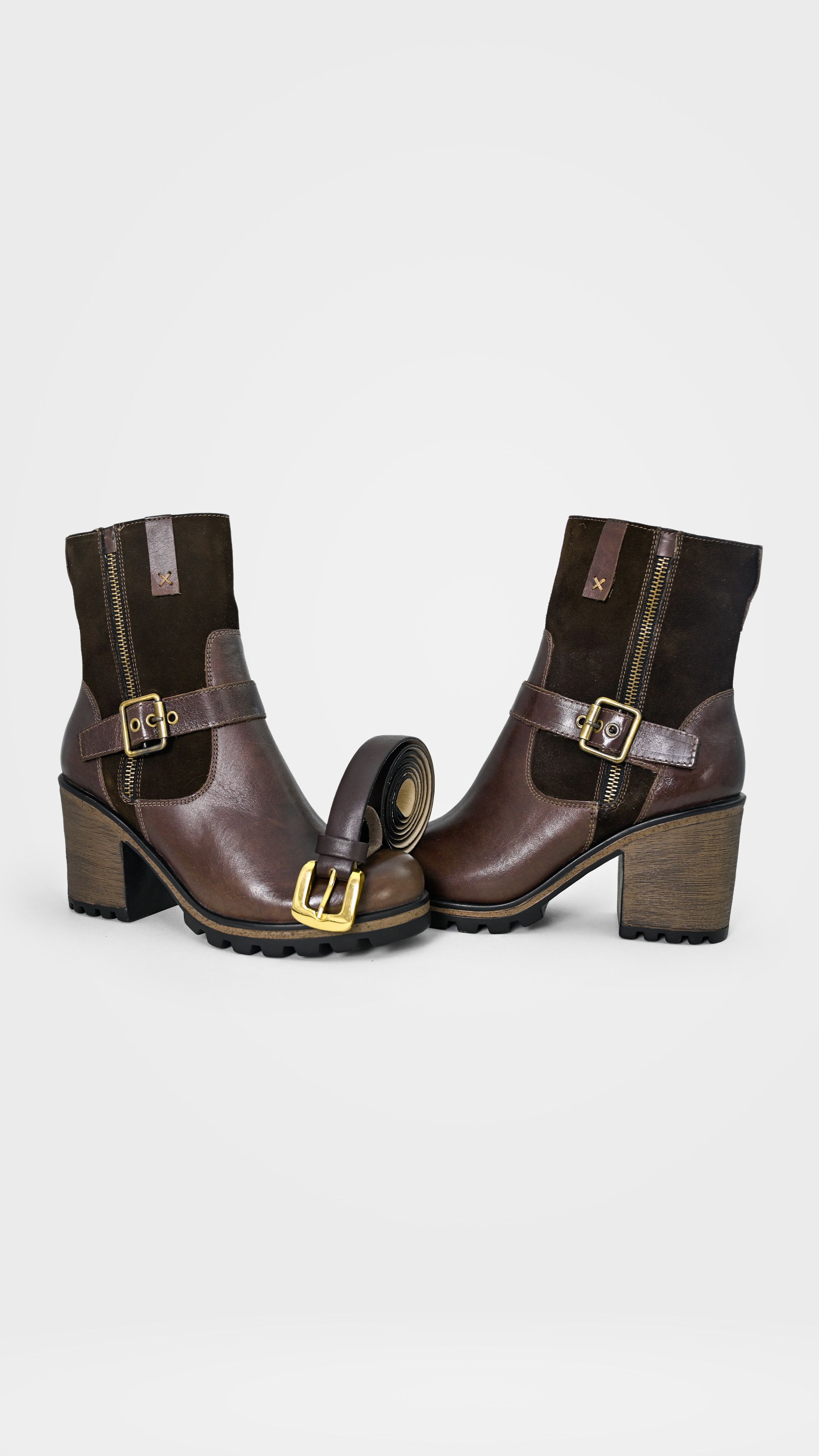 Elegant brown leather boots paired with a matching belt in a studio setting.