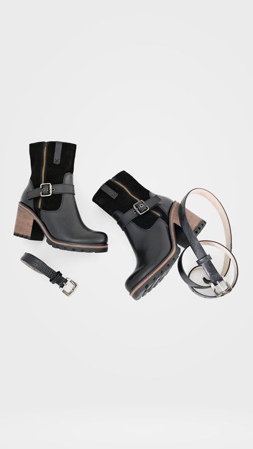 Free A stylish arrangement of black leather boots and belts on a white background. Stock Photo