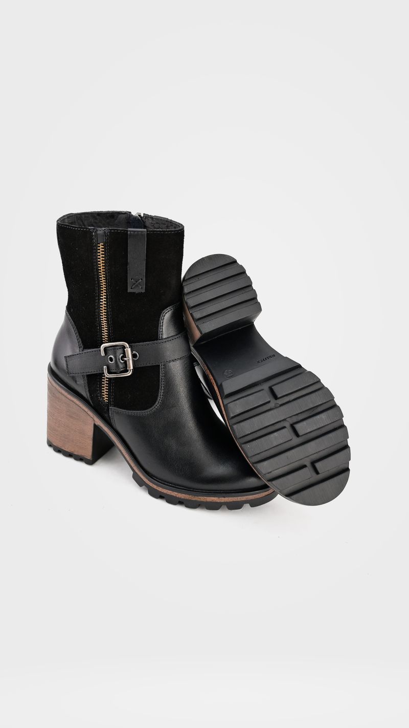 Bottines à talon en cuir noir avec boucle sur fond blanc