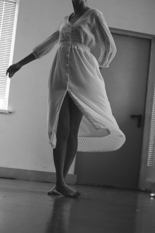 Black and White Photo of Woman in a Dress Dancing