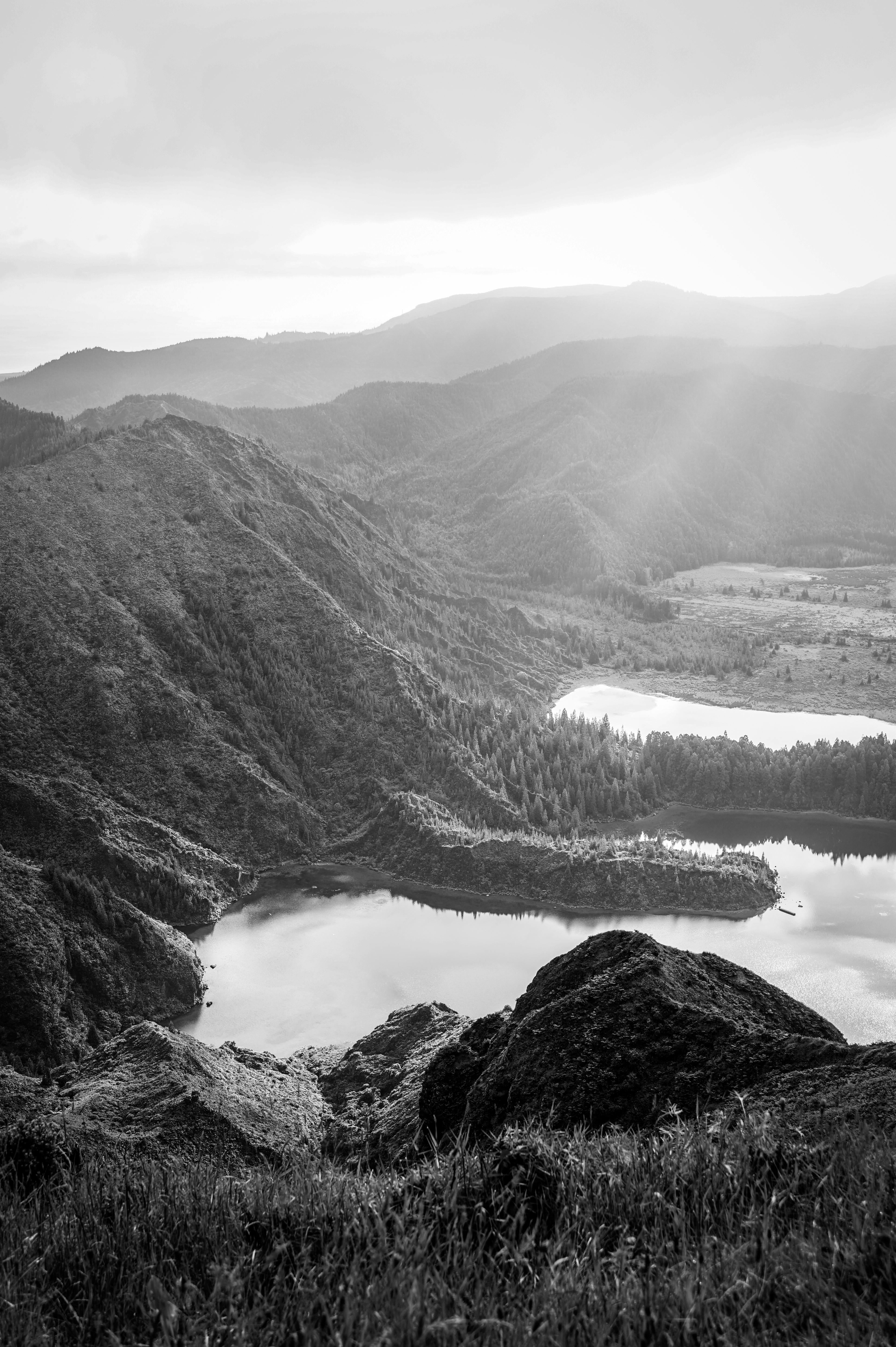 A stunning black and white aerial view of Sete Cidades, showcasing tranquil lakes and lush hills in the Azores, Portugal.