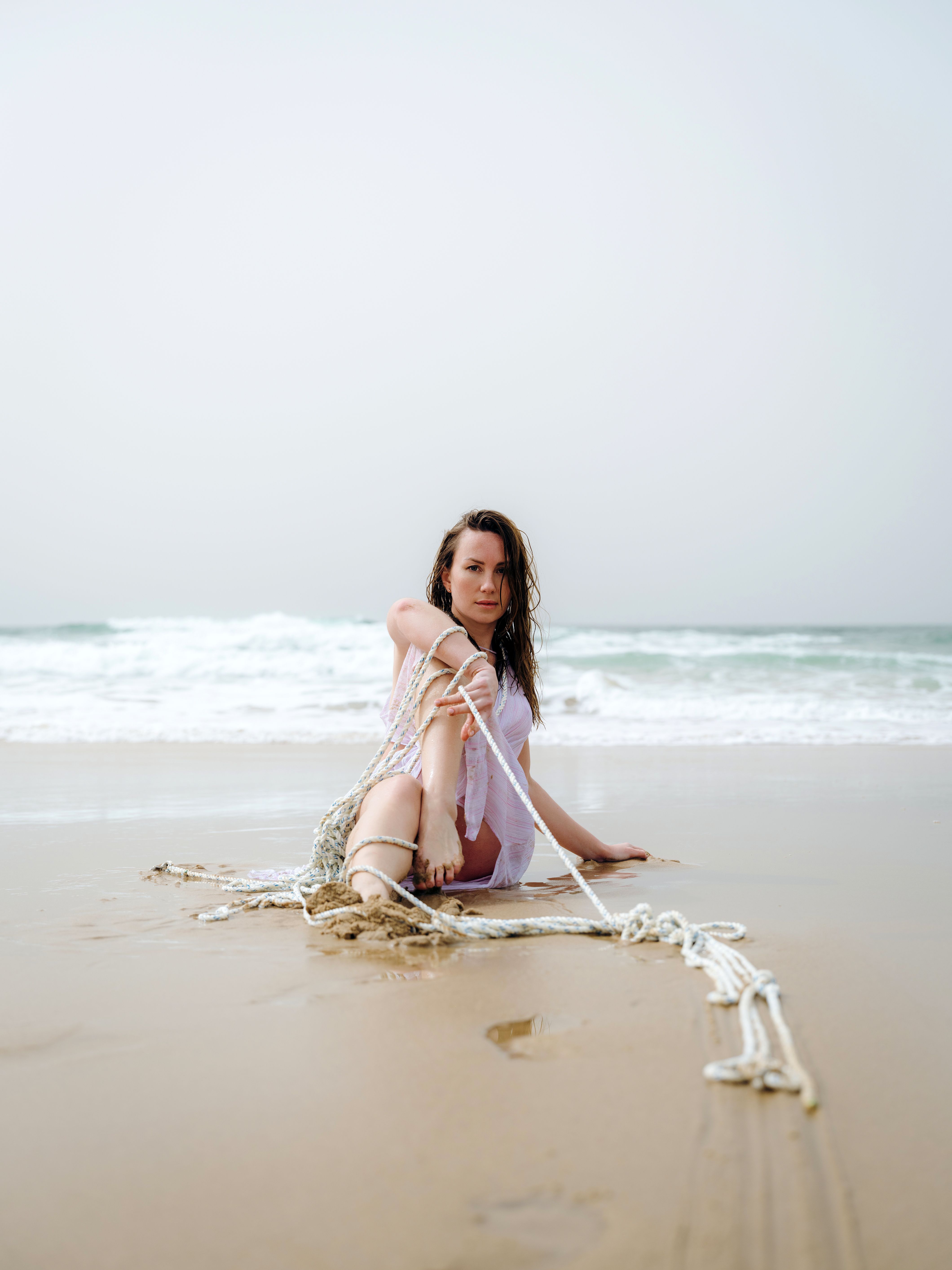 Woman Sitting with Rope on Beach · Free Stock Photo