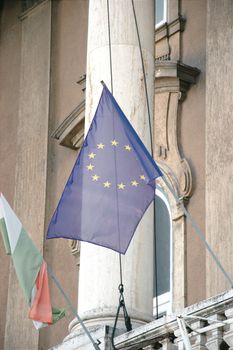 Close-up of EU and Hungarian flags on a historic building column in Budapest, Hungary.