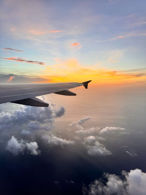Free A beautiful view of a sunset from an airplane window, showcasing the wing and clouds. Stock Photo
