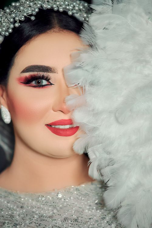 Free Stunning bride with elegant makeup and feather details, ideal for wedding themes. Stock Photo