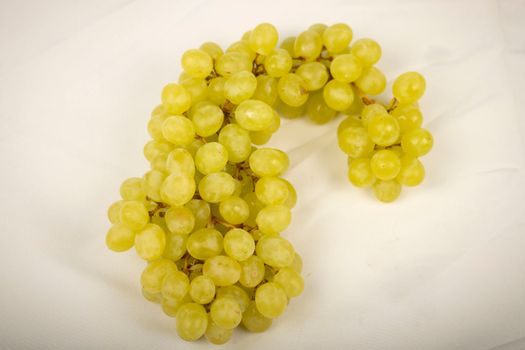 A bunch of grapes on a white surface