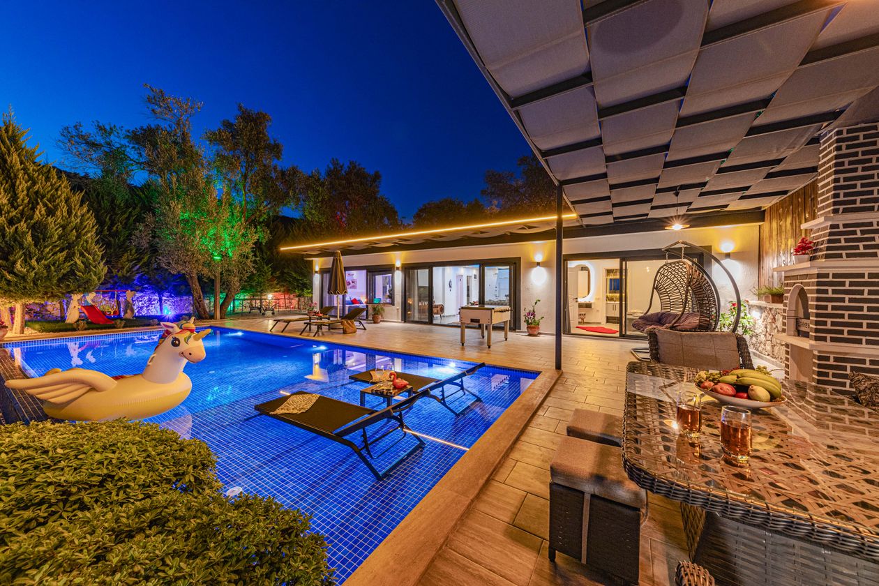 Modern villa with glowing swimming pool at dusk