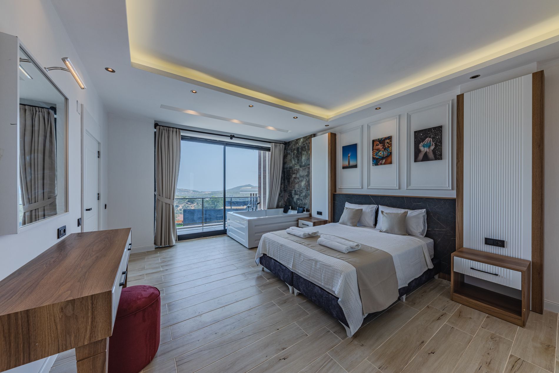 Corner guest room with a made bed, writing desk and a full-height window onto the terrace — photo by Ahmet ÇÖTÜR on Pexels
