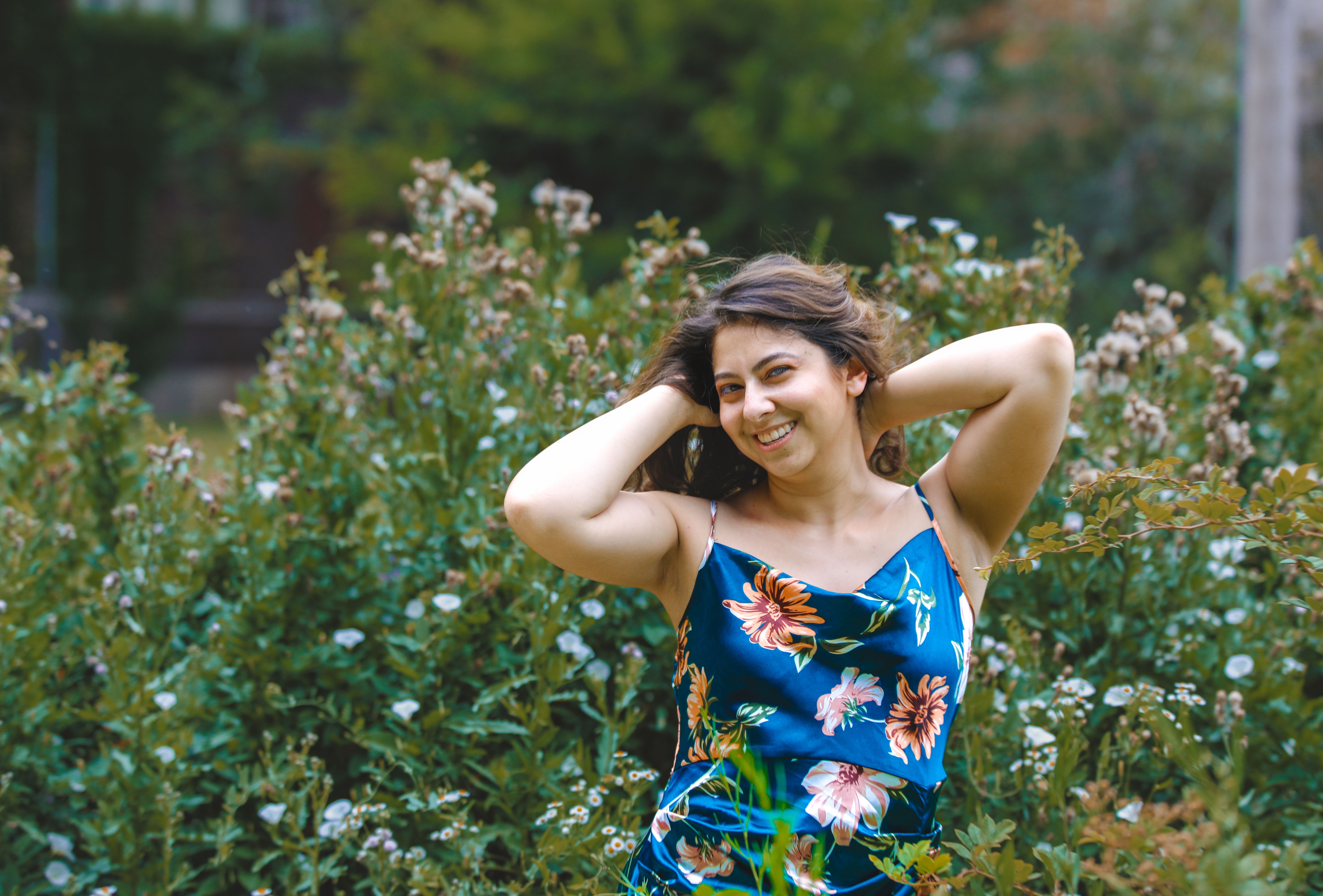 A Smiling Woman Standing in the Garden · Free Stock Photo