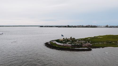 Free Scenic aerial view of Castle Pinckney on Charleston Harbor, highlighting historic ruins and serene ocean backdrop. Stock Photo