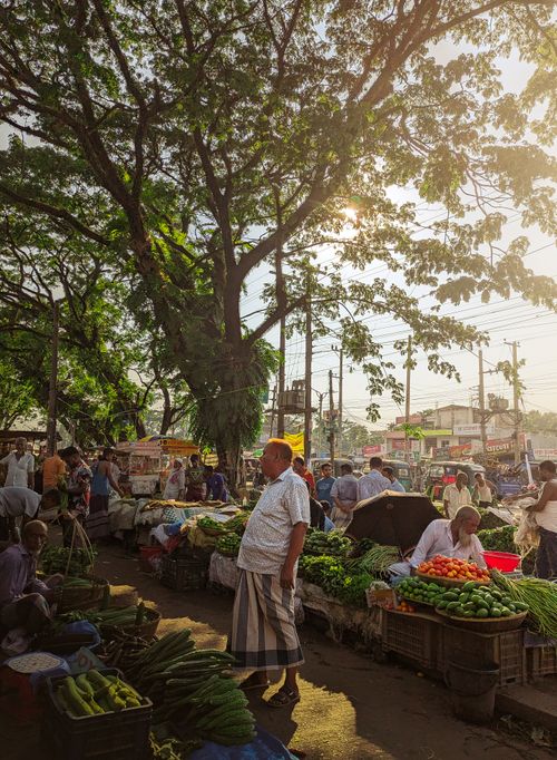 Free Vibrant outdoor farmers market with diverse produce and bustling activity under sunny skies. Stock Photo