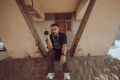 Free Stylish portrait of a man sitting under a unique structure in New Delhi, showcasing urban fashion. Stock Photo