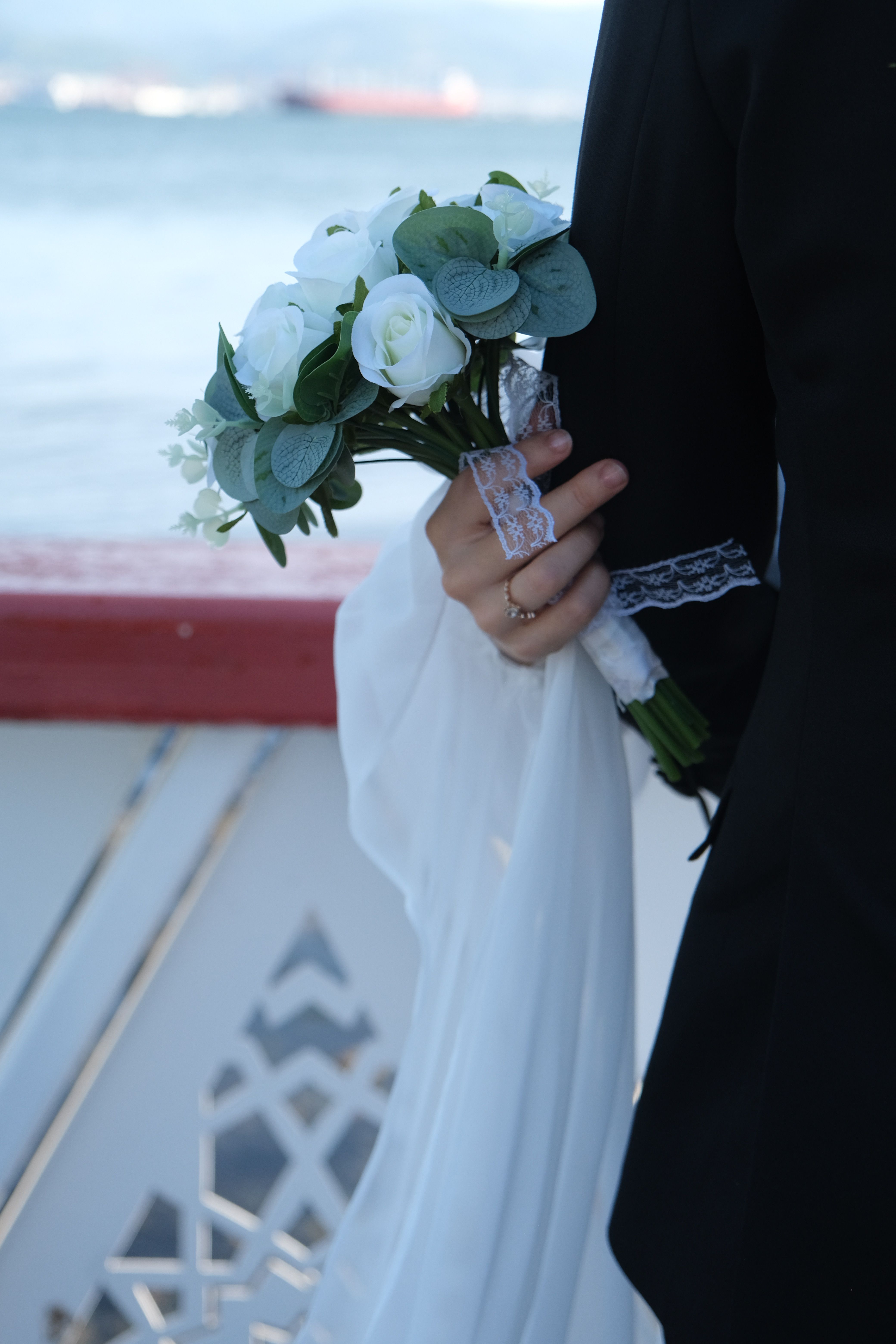 Bride Holding a Bouquet by the Waterfront · Free Stock Photo