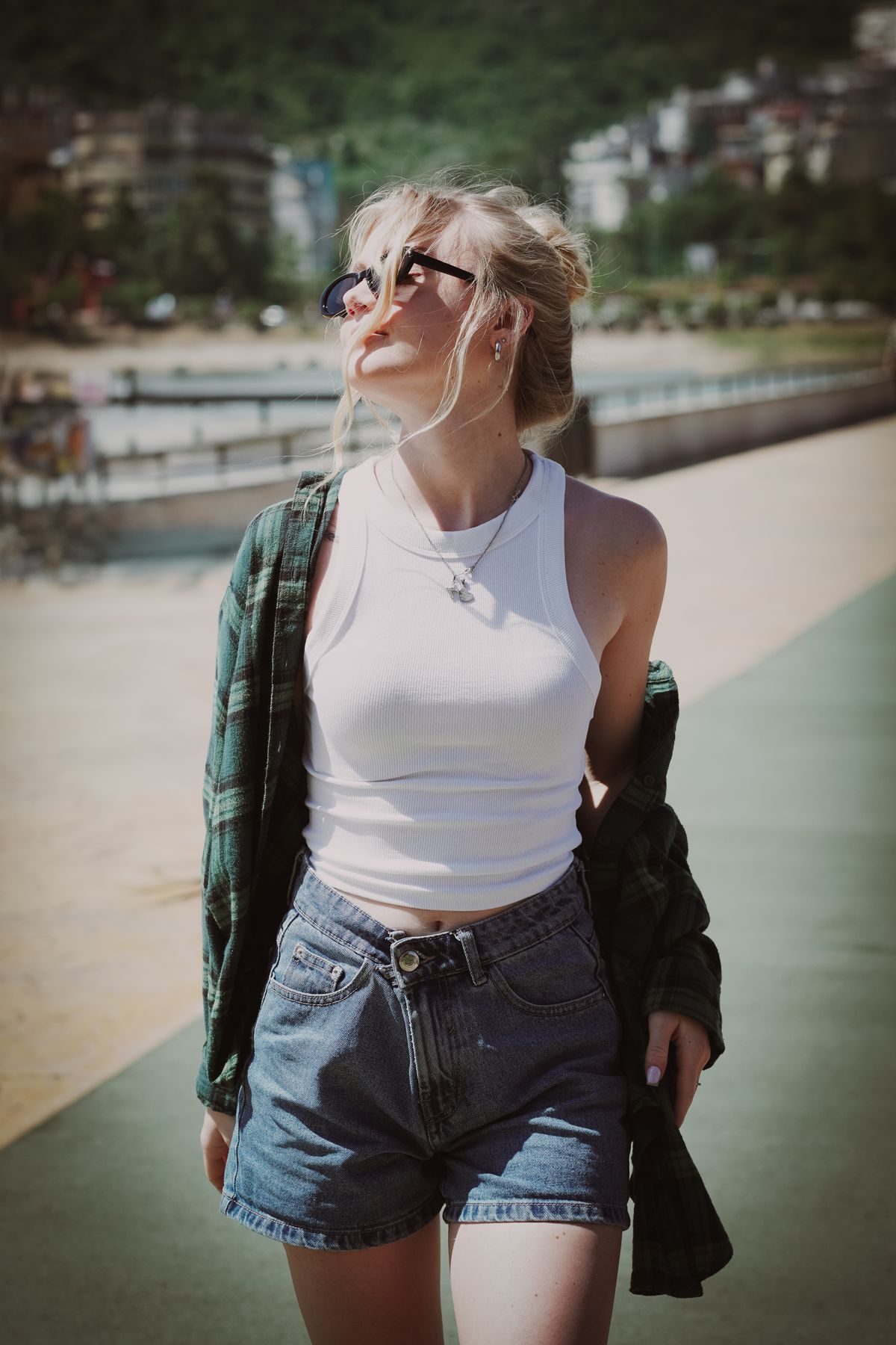 A woman in a tank top and denim shorts — the effortless summer denim short outfit