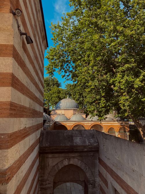 Free Explore Ottoman architecture with beautiful stonework and lush trees under a clear blue sky. Stock Photo
