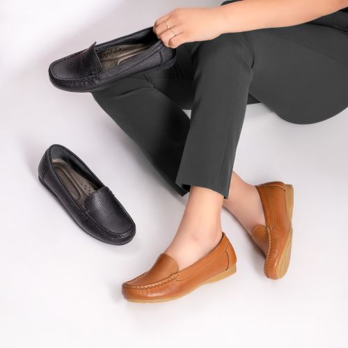 A pair of flat leather slip-on shoes on a plain surface. Photo by Jose Martin Segura Benites on Pexels.
