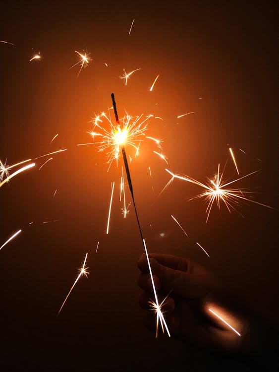Photo of Person's Hand Holding a Sparkler