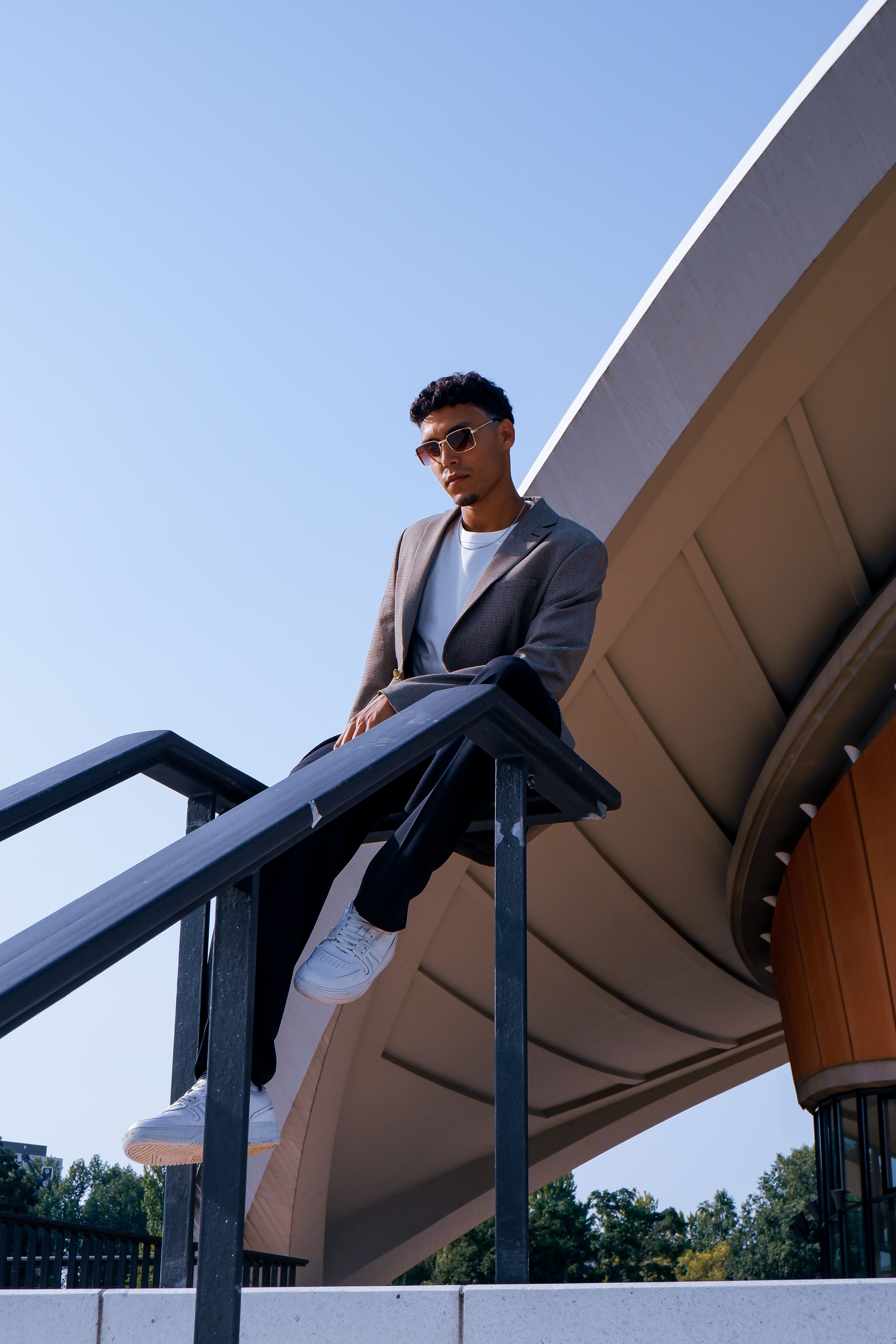 Young Man in a Gray Suit and White T-Shirt Sitting on a Railing · Free ...