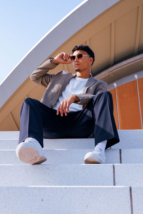 Free Young man in sunglasses posing on stairs, showcasing smart casual fashion in Berlin. Stock Photo