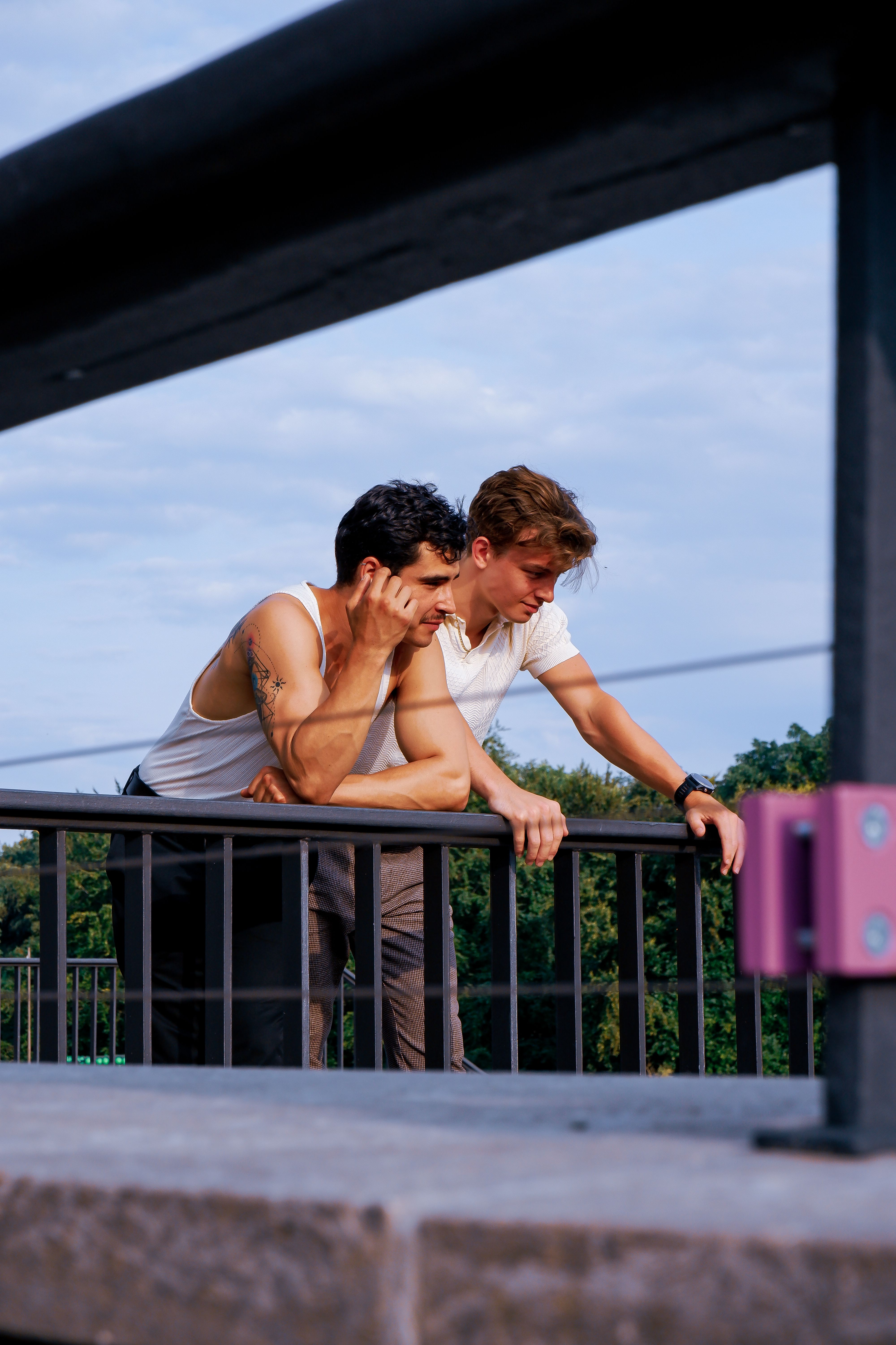 Two men are sitting on a railing looking out over the city · Free Stock ...