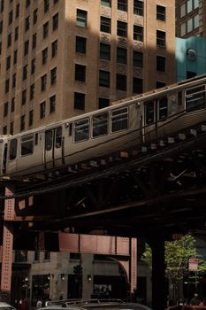 View of an elevated train passing by tall buildings in Chicago's urban scene.