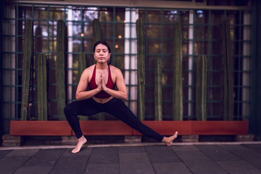Woman in activewear practicing yoga against cactus backdrop in Mexico City for mindfulness and fitness.
