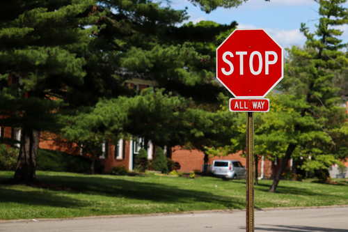 Free A stop sign on an Indianapolis street with suburban houses and lush green trees. Stock Photo