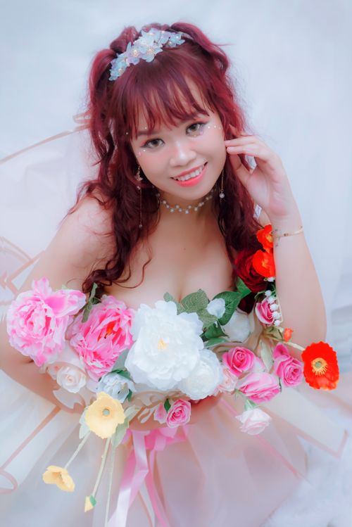 Free Charming young woman holding a vibrant bouquet of flowers, exuding elegance and joy. Stock Photo