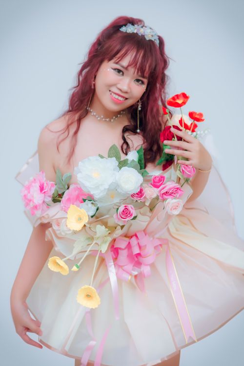 Free Young woman in a floral dress and dyed hair smiling elegantly. Stock Photo
