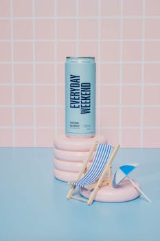 Chic lime flavored drink can on pastel background with mini beach chair. Perfect summer refreshment.