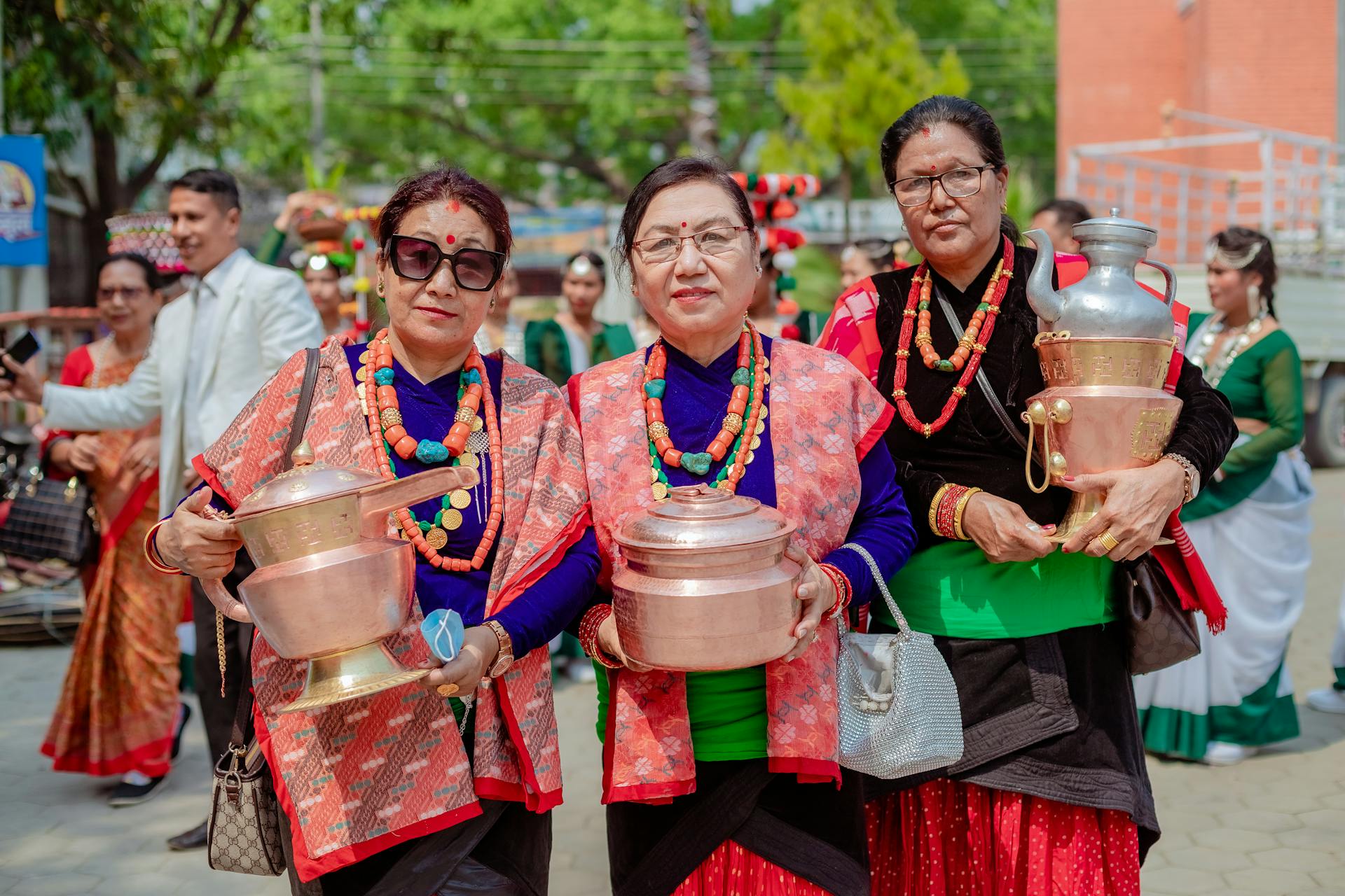 Women In Traditional Clothing Holding Copper Vessels