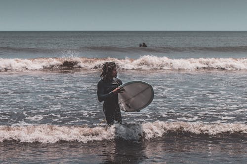 Photo D'un Homme Portant Une Planche De Surf