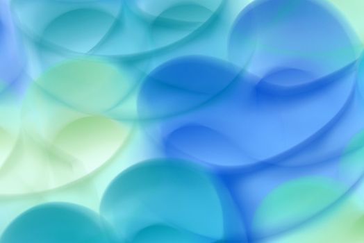 A vibrant abstract art piece with overlapping blue and green shapes creating a smooth gradient effect.