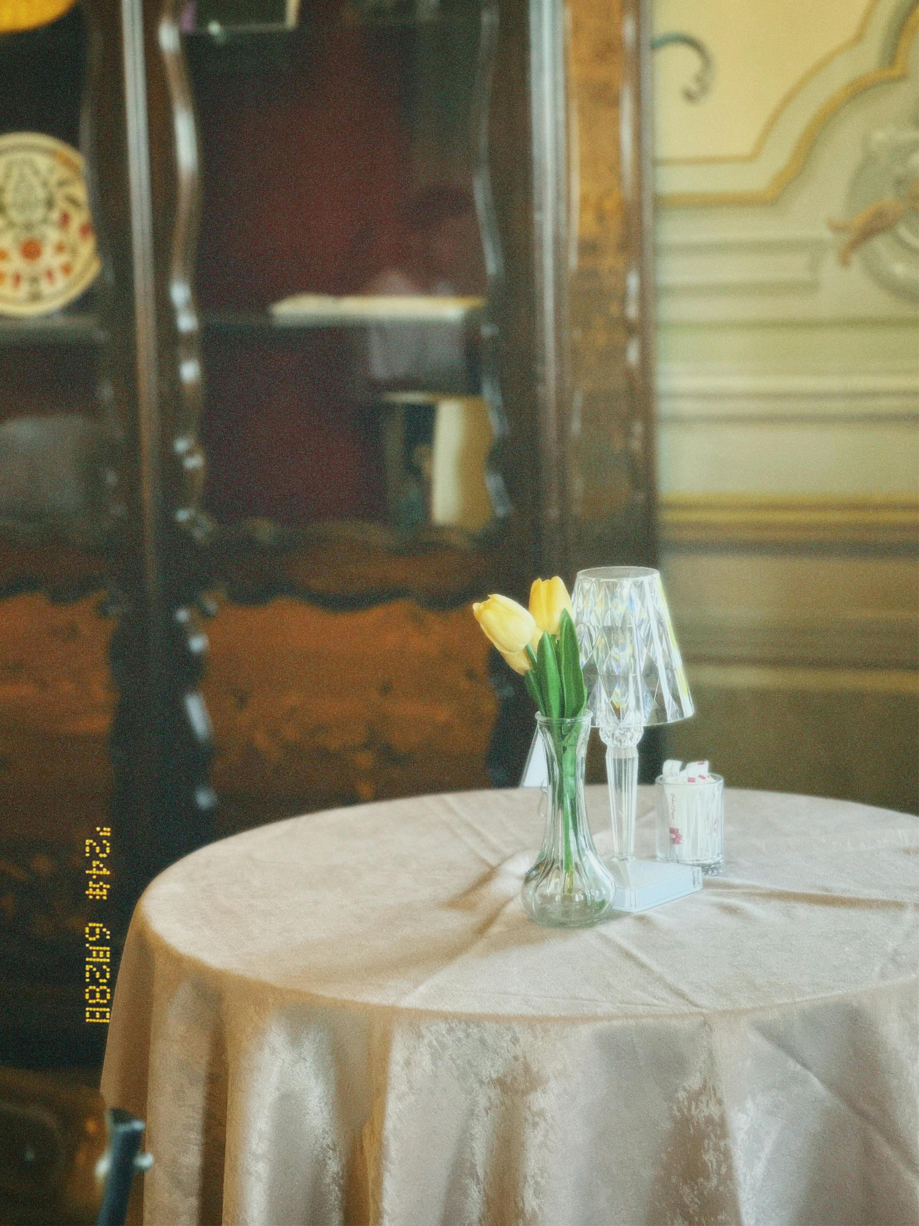 Elegant vintage dining room featuring a table with tulips and glassware creating a nostalgic ambiance.