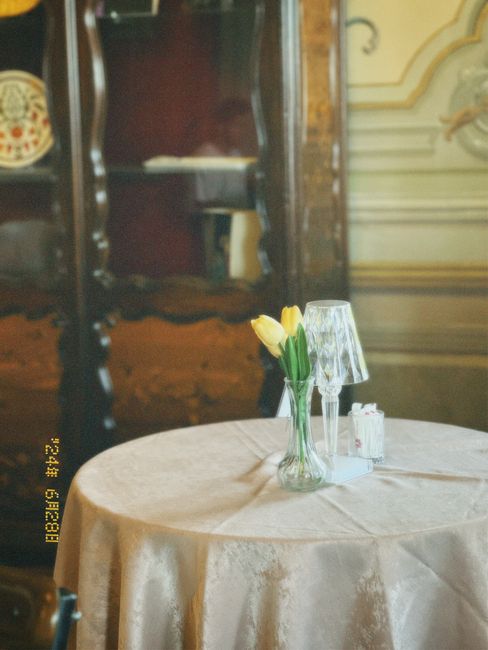 Elegant vintage dining room featuring a table with tulips and glassware creating a nostalgic ambiance.