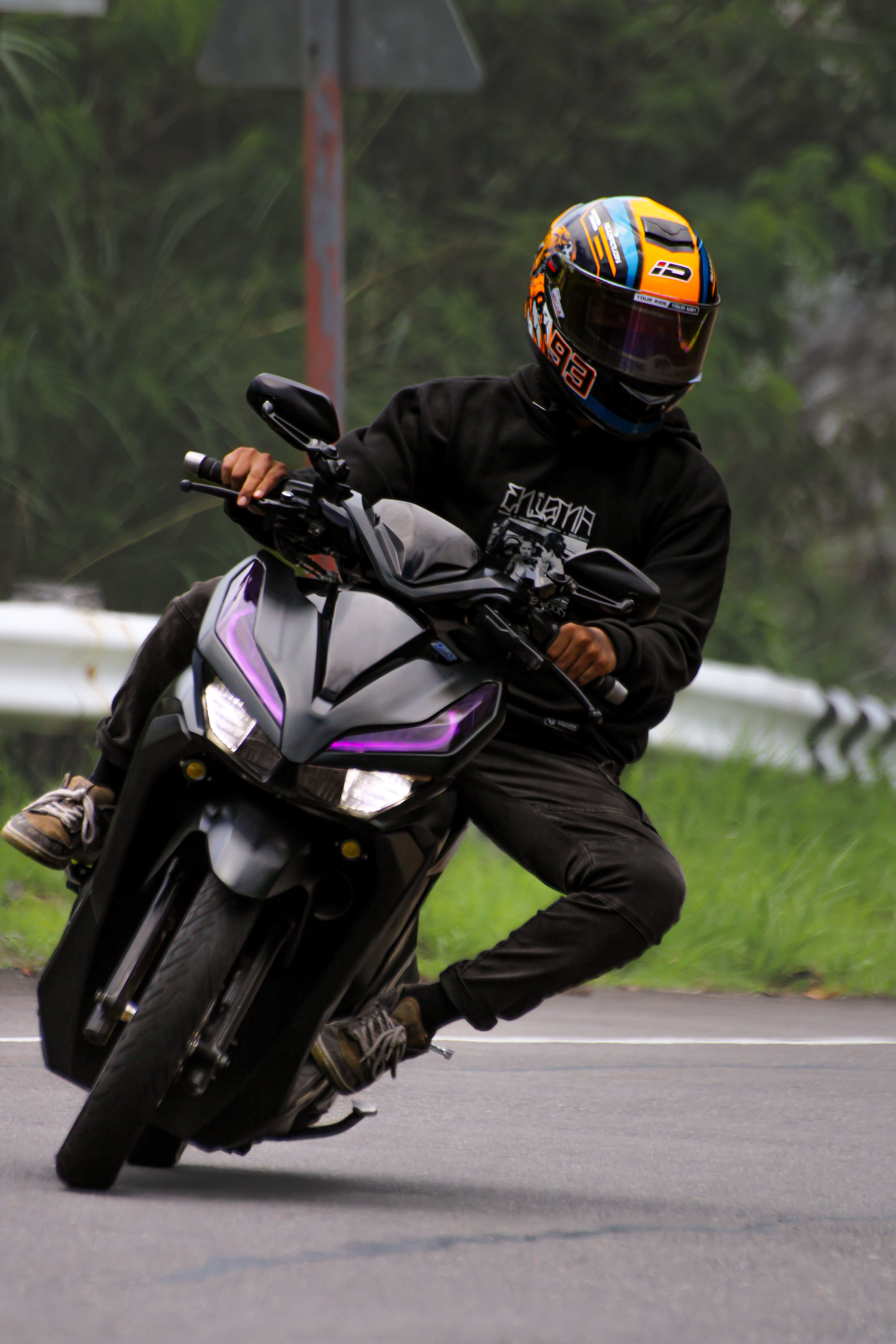 A biker skillfully leans into a turn on a curvy road, showcasing speed and precision riding.