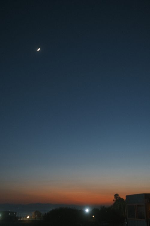 Free A serene dusk sky over Antalya with a crescent moon and rural landscape. Stock Photo