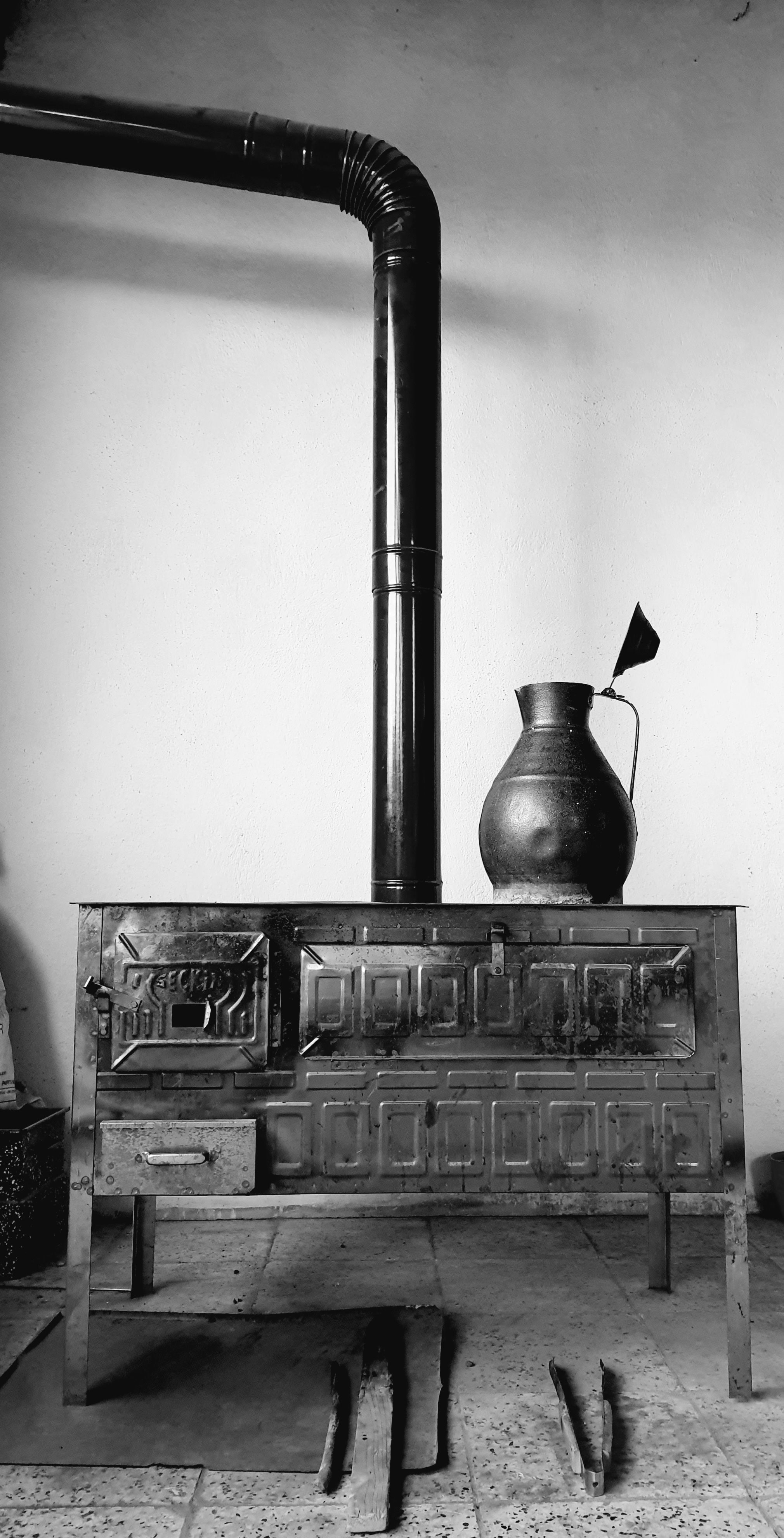 A retro stove with a black pipe and jug in a vintage style kitchen.