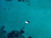 一艘孤独的船漂浮在希腊帕莱卡斯提察清澈的碧绿水域上