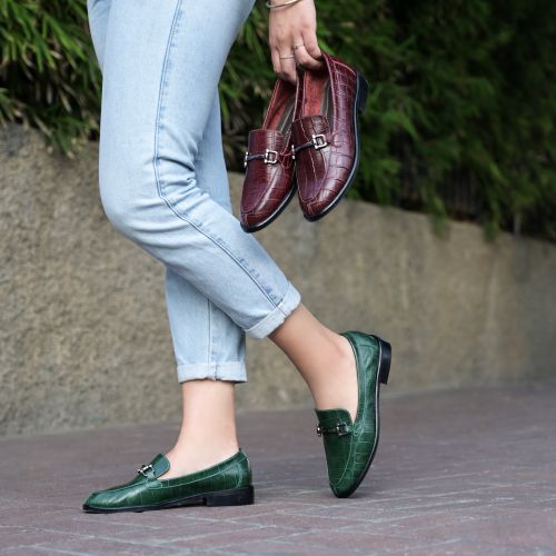 Free A chic woman showcasing red and green loafers in a city setting, wearing light denim jeans. Stock Photo