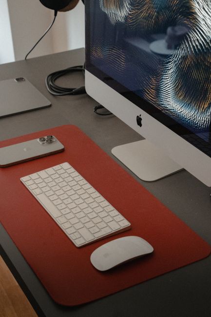 Fotomural Configuración de oficina elegante con un iMac y un iPhone que muestra tecnología moderna en un espacio de trabajo corporativo.