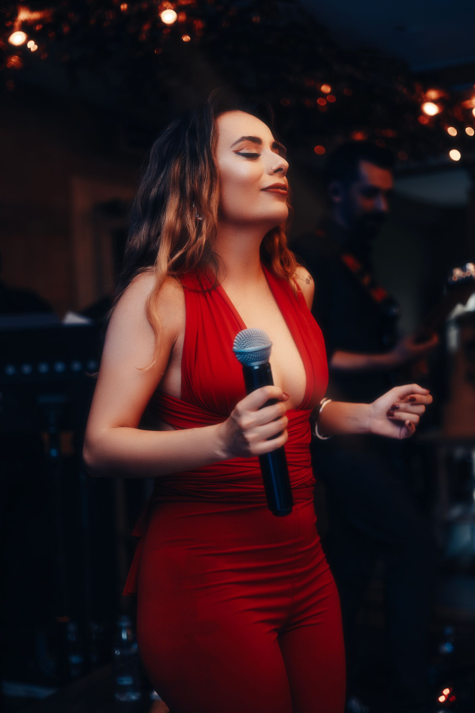 A singer in a red outfit performing on stage