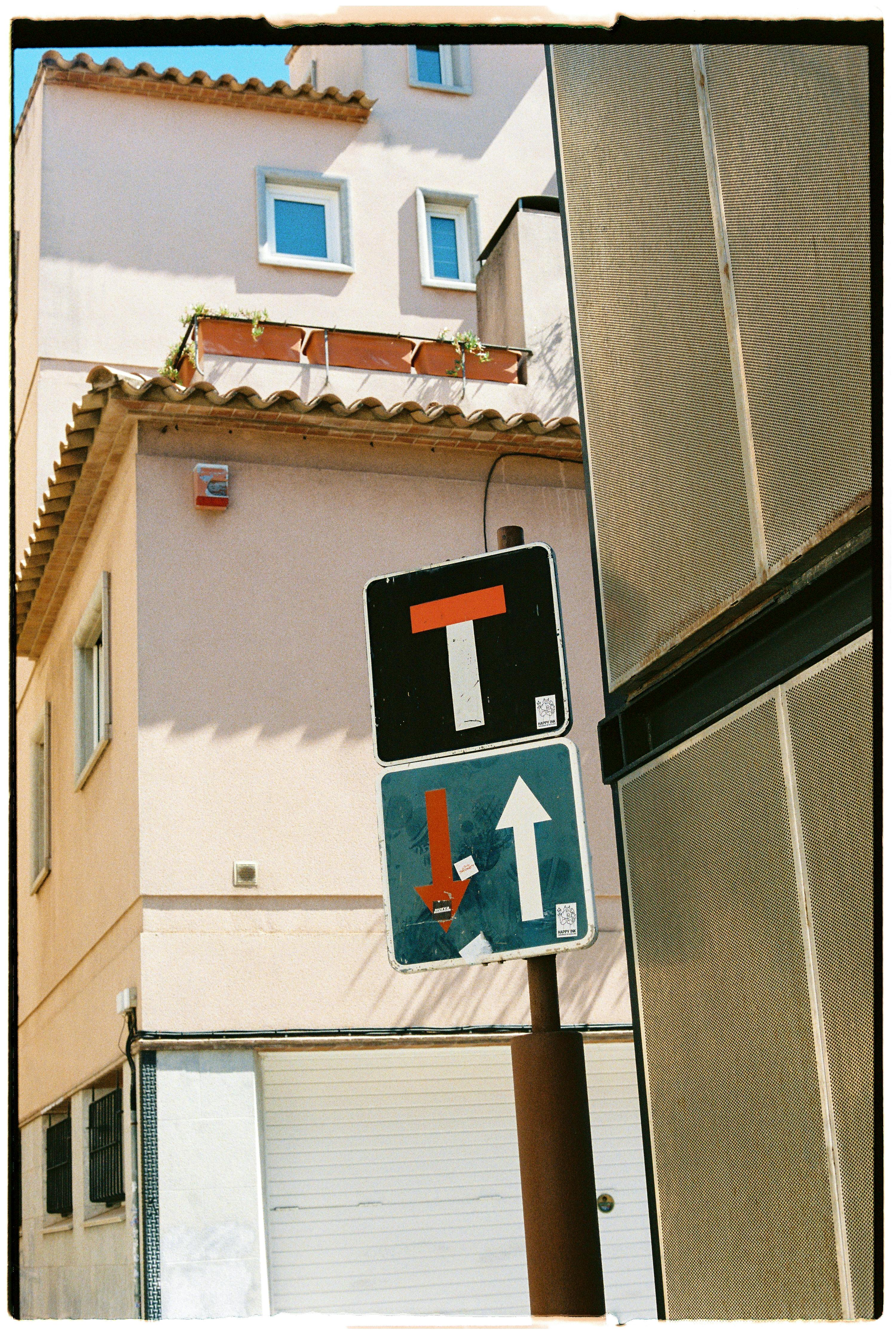 Traffic signs in a narrow sunlit alley highlighting an urban setting.
